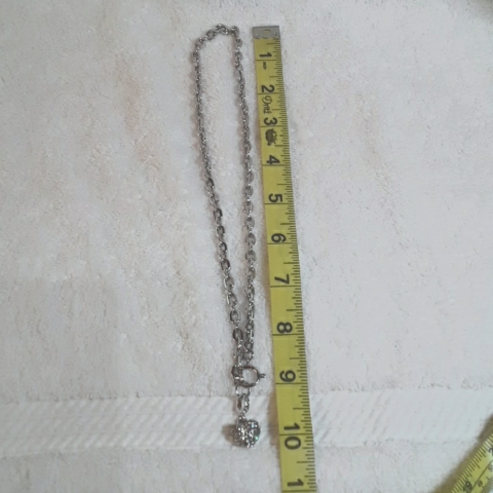 Silver necklace with rhinestone heart charm.